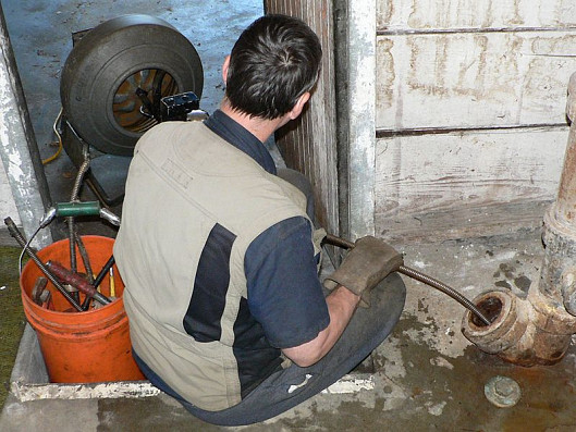 A plumber augers a main sewer line to a house. Photo: Walter Siegmund/Wikimedia Commons.